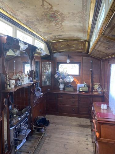 a kitchen with wooden cabinets and a ceiling at Vintage Showman's Wagon For Two Close to Beach in Plymouth
