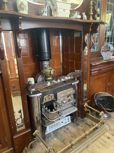 an old fashioned stove is on display in a room at Vintage Showman's Wagon For Two Close to Beach in Plymouth