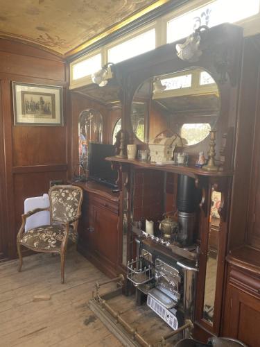 um quarto com um fogão antigo e uma cadeira em Vintage Showman's Wagon For Two Close to Beach em Plymouth