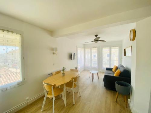 un salon avec une table et un canapé bleu dans l'établissement Appartement T2 4 Pers - Bord de Mer, au Grau-du-Roi