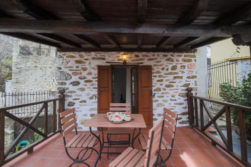 a wooden table and chairs on a balcony at Archontiko Naoumidi in Portariá