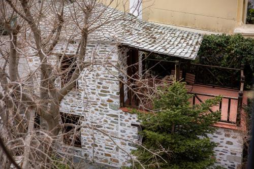 a stone house with a tree in front of it at Archontiko Naoumidi in Portariá