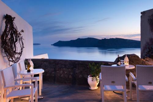 a dining room table with a view of the ocean at Enalion Suites in Oia