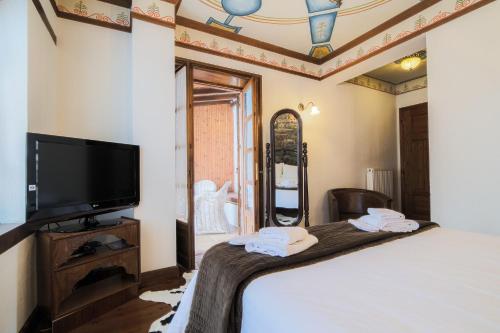 a bedroom with a bed and a flat screen tv at Archontiko Naoumidi in Portariá