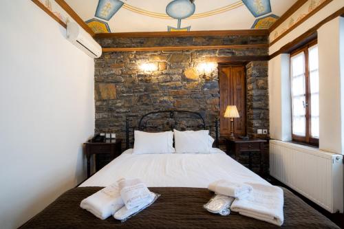 a bedroom with a bed with two towels on it at Archontiko Naoumidi in Portariá