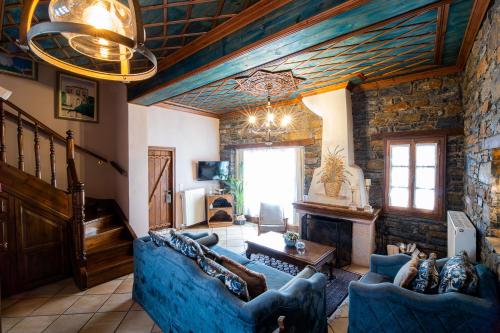 a living room with a blue couch and a fireplace at Archontiko Naoumidi in Portariá
