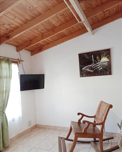 a living room with a chair and a television at Departamento para 3 in Esquel