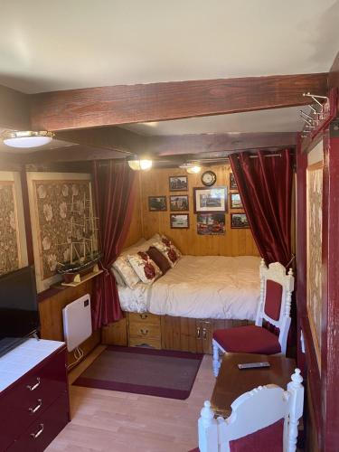 Cette chambre comprend un lit et un bureau. dans l'établissement Rare 1954 Renovated Vintage Lorry - Costal Location, à Plymouth