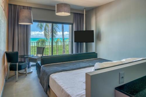 a hotel room with a bed and a view of the ocean at Vila Galé Resort Alagoas - All Inclusive in Barra de Santo Antônio