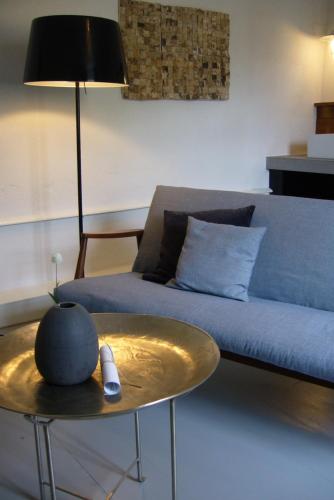 a living room with a blue couch and a table at La Paresse en Douce in Tours-sur-Meymont