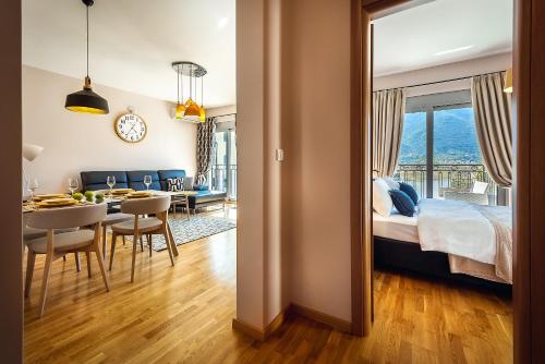a bedroom with a bed and a dining room with a table at 2MONTENEGRO LIMETA APARTMENTS with pool in Kotor