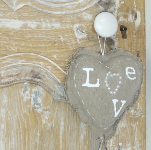 a heart with the word love hanging from a wall at La Paresse en Douce in Tours-sur-Meymont