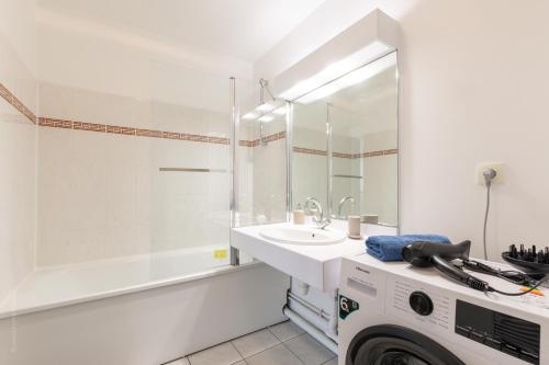 une salle de bain blanche avec un lavabo et un miroir dans l'établissement LA GARONNE - FAIRYTALE FACTORY, à Serris