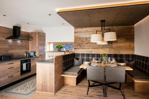 a kitchen and dining room with a table and chairs at Lerchpeuntgut Almchalets in Tamsweg