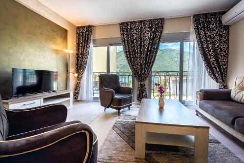 a living room with a couch and a tv at 2MONTENEGRO LIMETA APARTMENTS with pool in Kotor