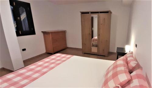 um quarto com uma cama e um armário de madeira em Comfy Apartment with WiFi and Free Parking em Arguineguín