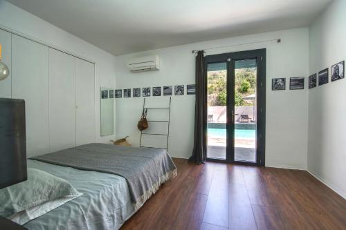 Saint-Étienne-du-GrèsにあるMaison Arty Provenceのベッドルーム1室(ベッド1台付)、スライド式ガラスドアが備わります。