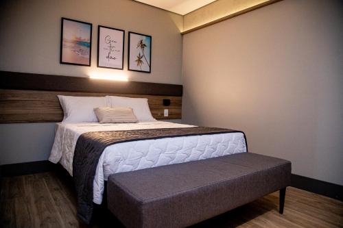 um quarto com uma cama e um banco em Hotel Vila Catavento em Petrolina