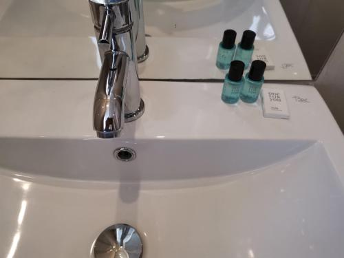 ein Waschbecken mit zwei Flaschen darüber in der Unterkunft Hotel Albert II Oostende in Ostende