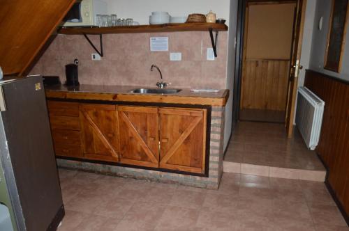 a kitchen with wooden cabinets and a sink at Cabaña Maitén in San Carlos de Bariloche