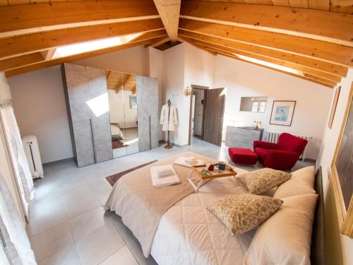 1 dormitorio con 1 cama grande y 1 silla roja en VILLA SILVIA-by Home Sitter Como, en Como