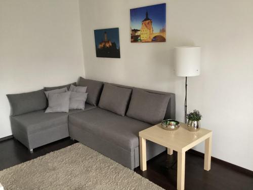 a living room with a gray couch and a table at Relaxen vor den Toren Bambergs in Bischberg