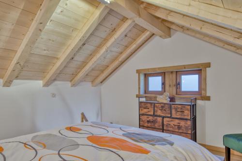 a bedroom with a bed and a wooden ceiling at Mazot savoyard situé à 25 kms de CHAMONIX in Saint-Gervais-les-Bains