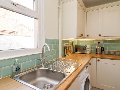 een keuken met een wastafel en een raam bij Seaside Retreat in Lowestoft