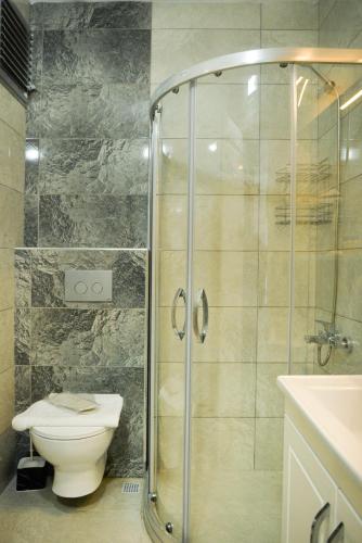 a bathroom with a shower and a toilet and a sink at Melissa Suite in Trabzon