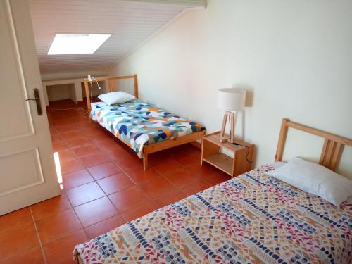 um quarto com duas camas e um candeeiro no chão em Hakuna Matata Hostel na Zambujeira do Mar