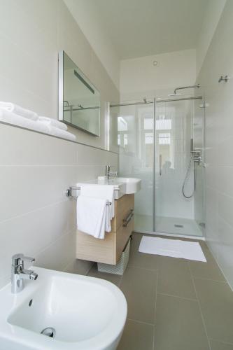 a white bathroom with a sink and a shower at Luxury Apartments Centre of Opatija in Opatija