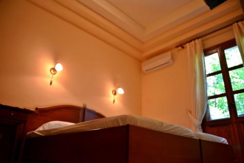 a bedroom with a bed and a window at Archontiko tou Ziaka in Ipáti