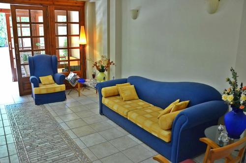 a living room with a blue couch and a chair at Archontiko tou Ziaka in Ipáti