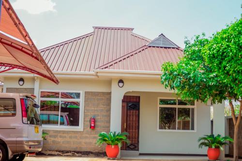 a house with a van parked in front of it at Randa Family House - Moshi in Himo