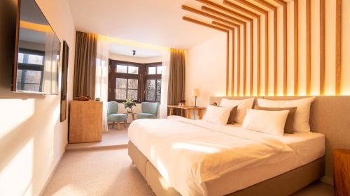 a bedroom with a large white bed in a room at Boutique Hotel Soyka in Špindlerův Mlýn