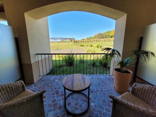 a patio with a table and chairs on a balcony at HOTEL TERMAS VICTORIA Wellness Spa in Victoria
