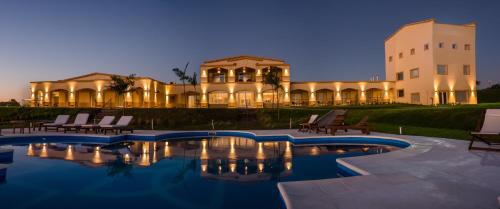 a house with a swimming pool in front of a building at HOTEL TERMAS VICTORIA Wellness Spa in Victoria