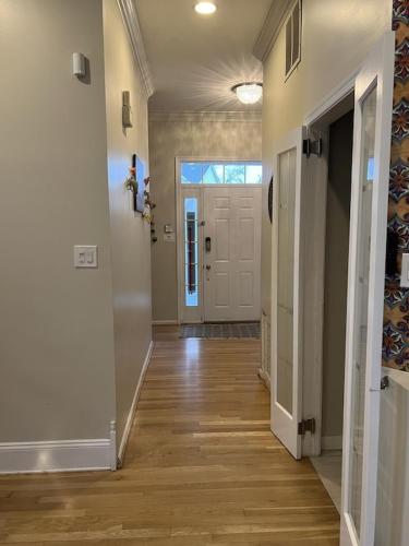 a hallway of a home with a door and wooden floors at 5BRwithBand&Piano setup Private Gym Theater&Entry at Cherry Hill in Cherry Hill