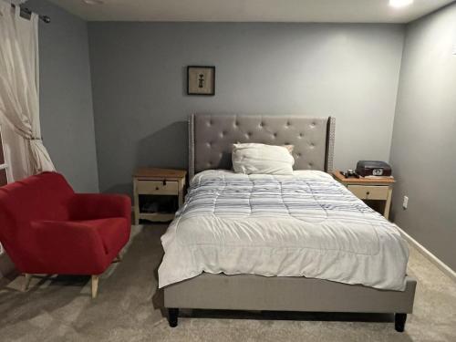 a bedroom with a bed and a red chair at 5BRwithBand&Piano setup Private Gym Theater&Entry at Cherry Hill in Cherry Hill
