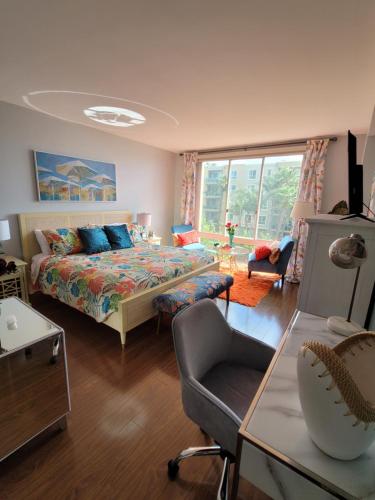 a bedroom with a bed and a chair in a room at Oceanfront lux condo in Long Beach