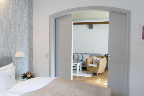a bedroom with a mirror and a living room at Hotel Ratsstuben in Lindau