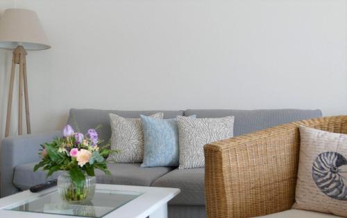 a living room with a couch and a vase of flowers at Hotel Ratsstuben in Lindau