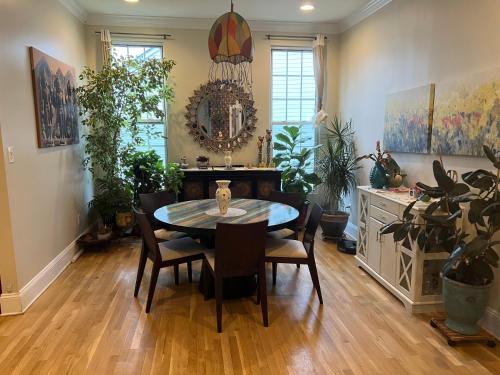 uma sala de jantar com mesa, cadeiras e plantas em Cherry Hill House em Cherry Hill