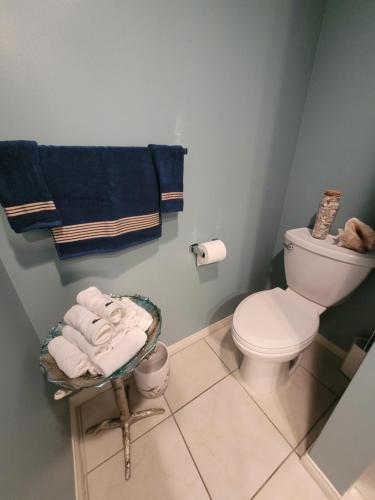 a bathroom with a toilet and towels in it at Oceanfront lux condo in Long Beach