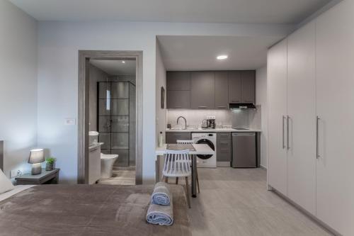 a kitchen with white cabinets and a table in a room at Eva's Studio in Heraklio