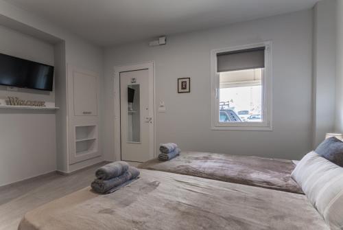 a bedroom with two beds and a flat screen tv at Eva's Studio in Heraklio