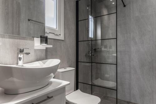 a bathroom with a sink and a glass shower at Eva's Studio in Heraklio