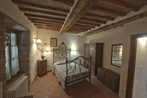 Schlafzimmer mit einem Bett mit einem schmiedeeisernen Bettrahmen in der Unterkunft Agriturismo Casa del Chiodo in Torniella