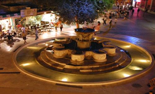 a fountain in the middle of a street at night at Eva's Studio in Heraklio