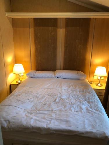 a bedroom with a large bed with two lamps at Gold Caravan in Harrietsfield